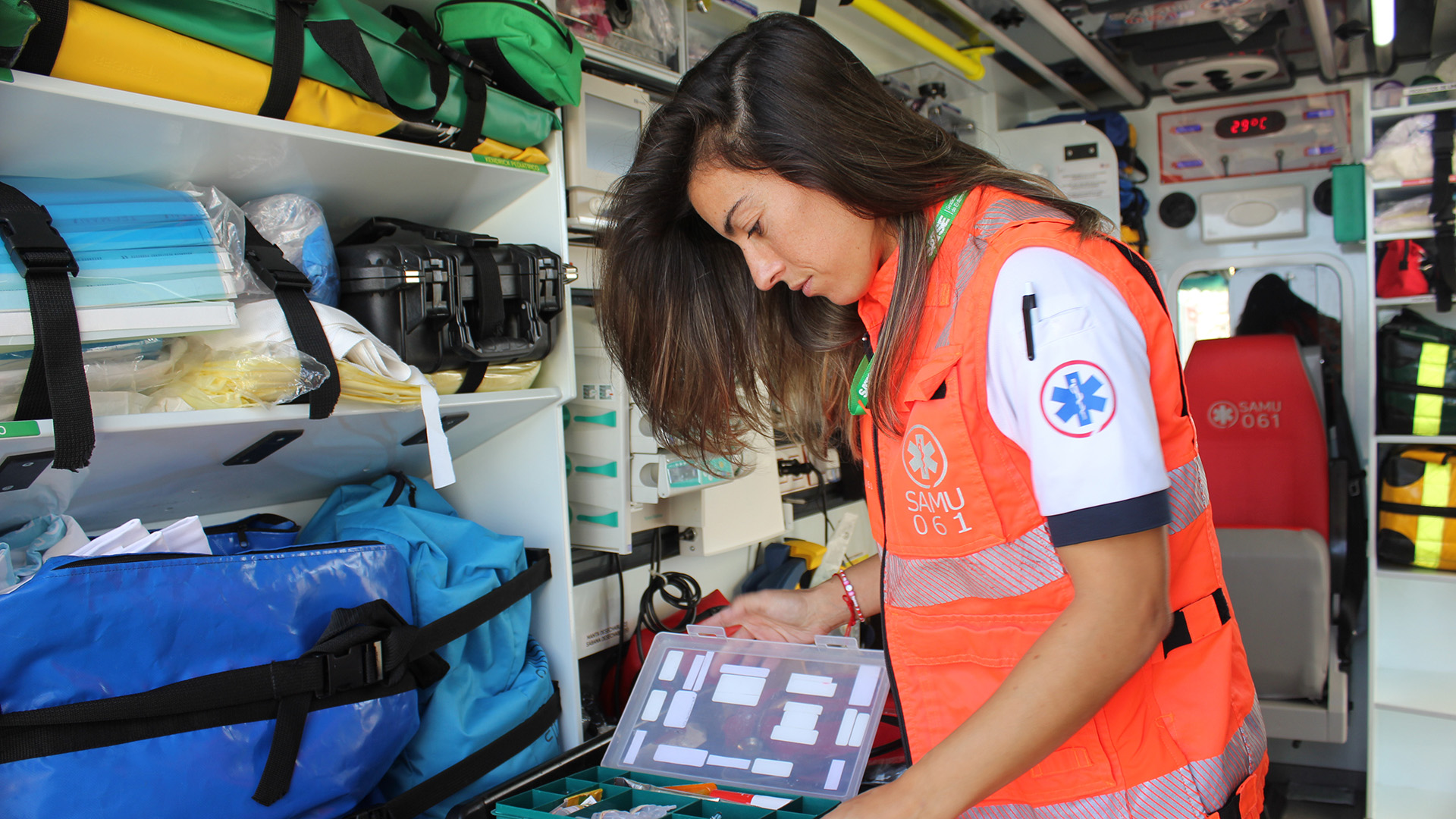 Enfermera de urgencias buscando medicación en una ambulancia